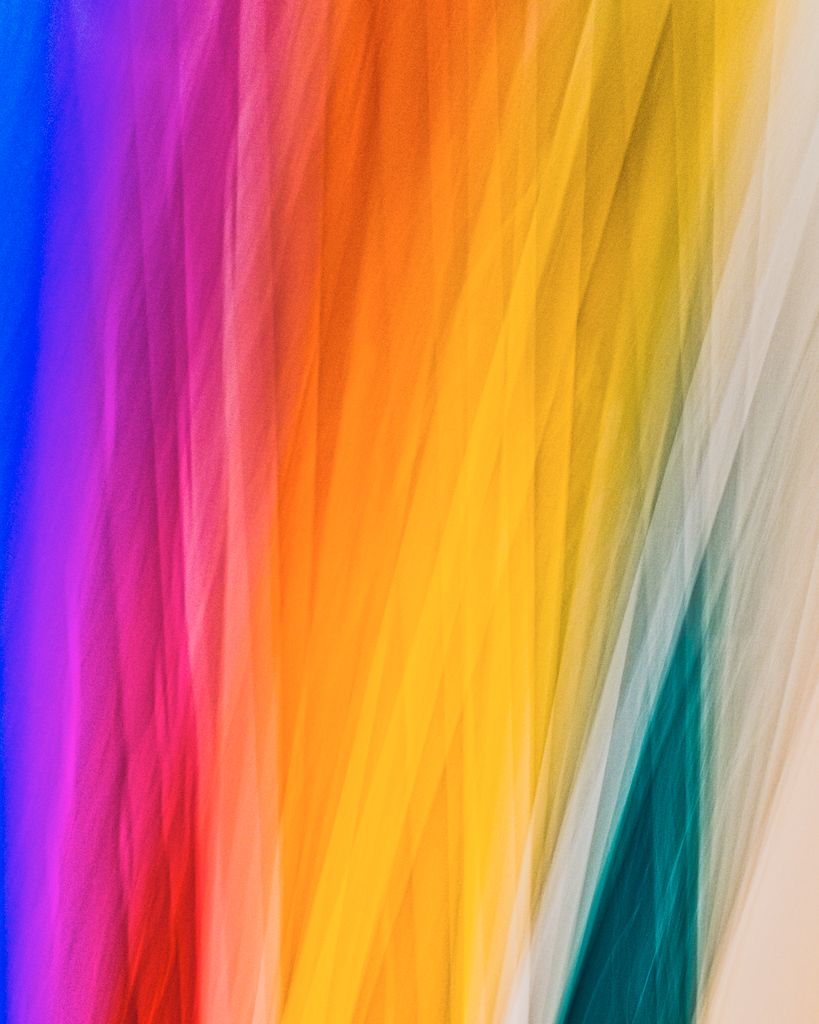 Dynamic abstract image featuring a vibrant spectrum of rainbow colors in diagonal stripes.